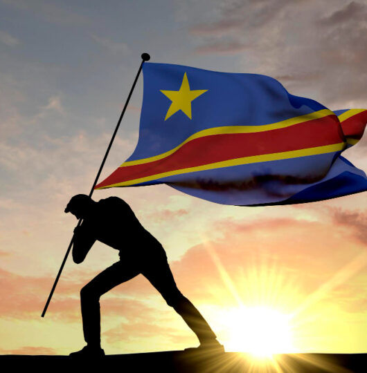 democratic-republic-congo-flag-being-pushed-into-ground-by-male-silhouette-3d-rendering